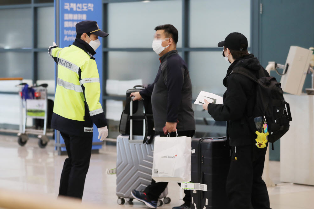 신종 코로나바이러스 확산 방지를 위해 한국철도(코레일)가 해외입국자 전용 KTX 칸과 공항버스 운행을 시작한 28일 오후 인천국제공항을 통해 입국한 프랑크푸르트발 입국자들이 경찰을 통해 전용 버스 관련 안내를 받고 있다. 연합뉴스