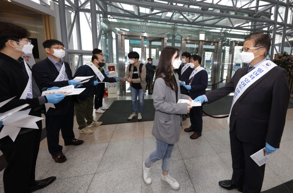 17일 인천공항공사와 서울지방항공청이 합동으로 시행한 사회적 거리두기 캠페인에서 김철환 서울지방항공청장(오른쪽)과 관계자가 공사 직원에게 직장 내 코로나19 예방수칙이 담긴 리플렛을 배포하고 있다.