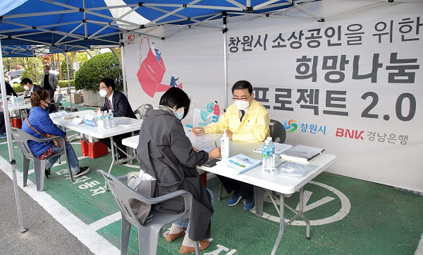 황윤철 BNK경남은행장(사진 왼쪽)과 허성무 창원시장이 희망나눔 프로젝트 2.0을 찾은 지역 소상공인들에게 금융상담을 하고 있다.