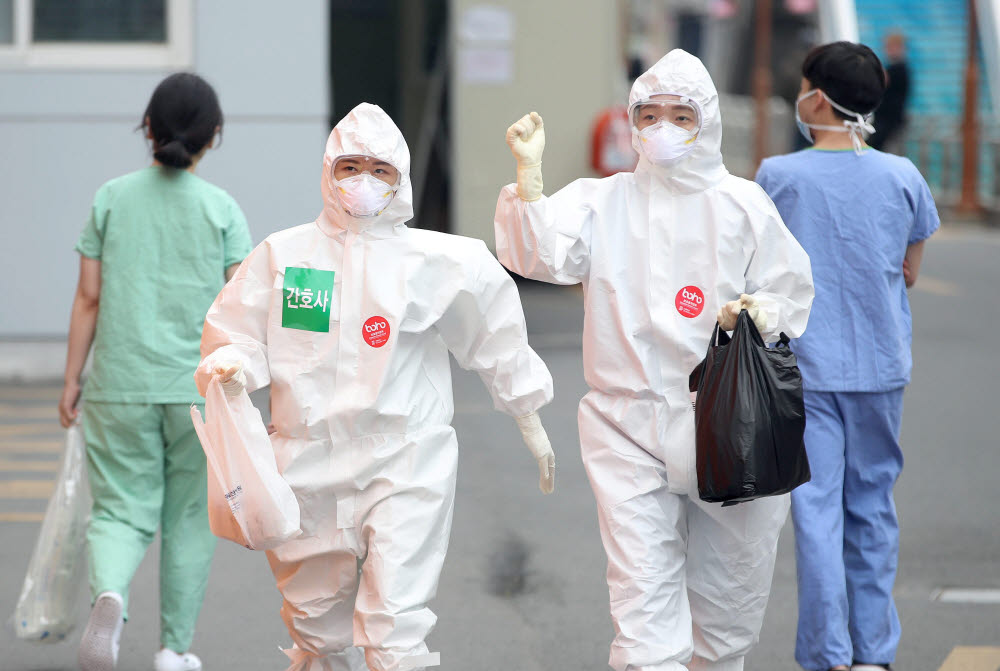 19일 대구시 계명대학교 대구동산병원 의료진들이 밝은 모습으로 코로나19 환자들이 입원한 병동으로 교대 근무를 위해 들어가고 있다. 연합뉴스