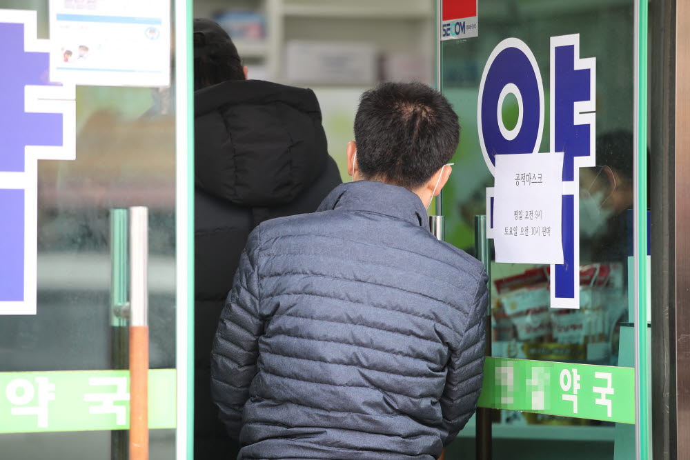 21일 오전 서울 종로구의 한 약국에서 시민이 공적 마스크를 사기 위해 줄을 서고 있다. 주중에 공적 마스크를 구매하지 못한 사람들은 출생연도와 상관없이 주말에 살 수 있다. 연합뉴스