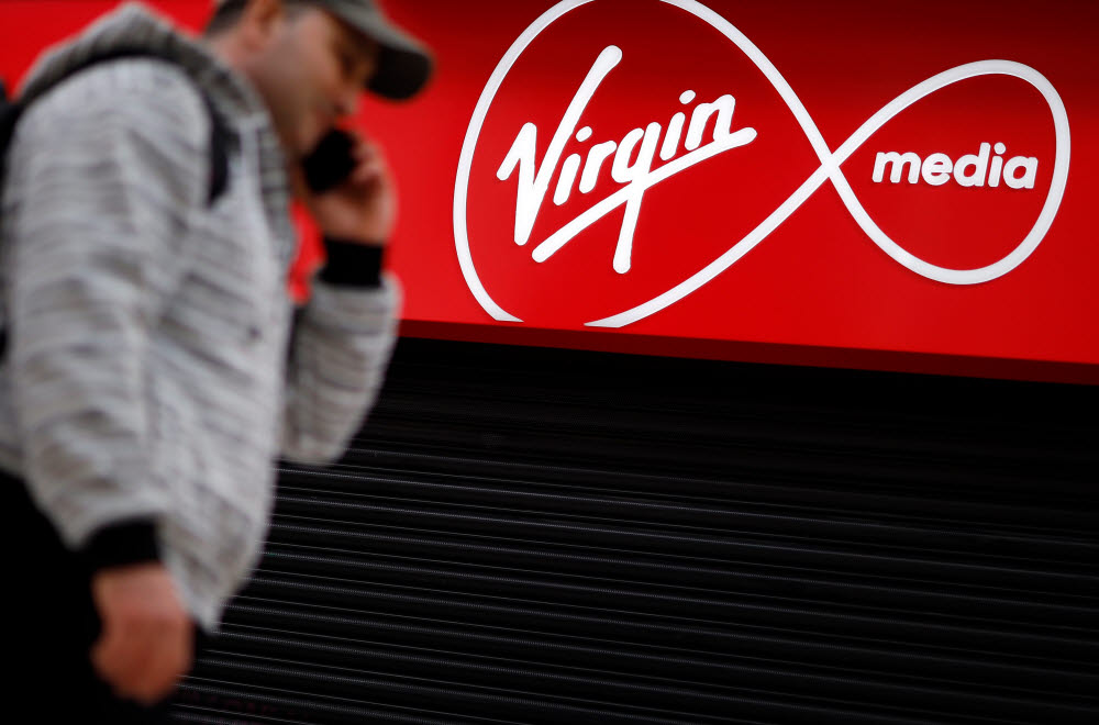 A person walks past a Virgin Media mobile phone store, closed-down due to the COVID-19 pandemic, in London on May 4, 2020. - Spanish group Telefonica on Monday said it was in talks with US cable giant Liberty Global to merge their telecoms operations in the UK. In a statement, Madrid-based Telefonica said it was in "talks... about a possible integration" of its O2 mobile business and Libertys Virgin Media that provides a mix of telecoms and television services, while providing caution over a deal ending up being struck. (Photo by Tolga Akmen / AFP)