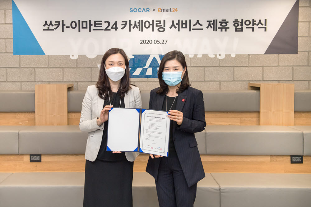 27일 쏘카 성수사무실에서 안혜선 이마트24 마케팅담당 상무(오른쪽)와 박진희 쏘카 사업본부장이 업무협약 체결 후 기념촬영을 하고 있다.