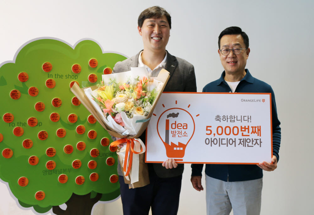 서울 중구 순화동 오렌지센터에서 5000번째 아이디어를 제안한 오렌지라이프 직원과 정문국 오렌지라이프 사장(오른쪽)이 기념촬영했다.