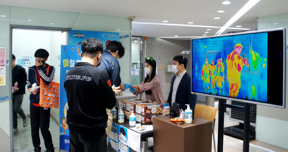 한국IT직업전문학교 관계자가 간단한 아침 먹거리를 준비해 등교생들에게 나눠주고 있다.