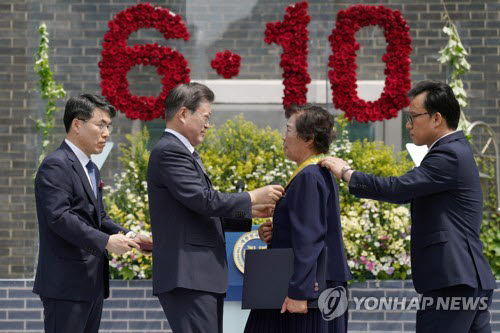 문재인 대통령이 10일 오전 서울 용산구 민주인권기념관에서 열린 6·10 민주항쟁 기념식에서 고(故) 이한열 열사 모친 배은심 여사에게 국민훈장 모란장을 수여하고 있다. 연합뉴스