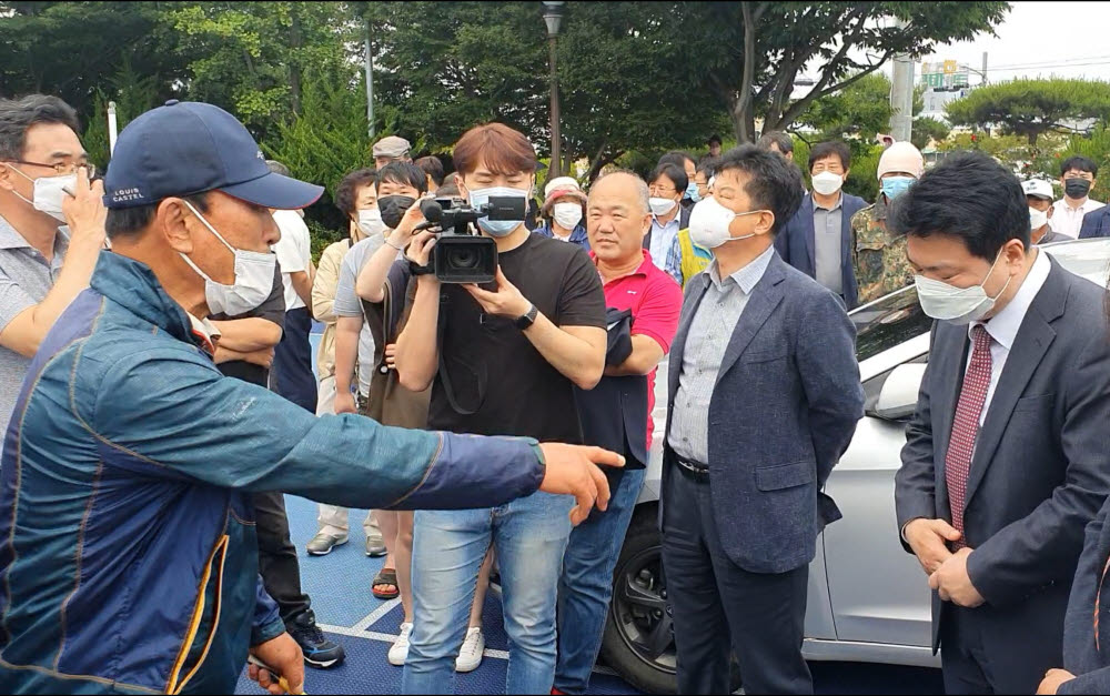 지난 12일 경북 경주시 양남면행정복지센터 운동장에서 양남면 한 주민(왼쪽)이 김대자 산업통상자원부 원전산업정책관(오른쪽)에게 항의하고 있다.