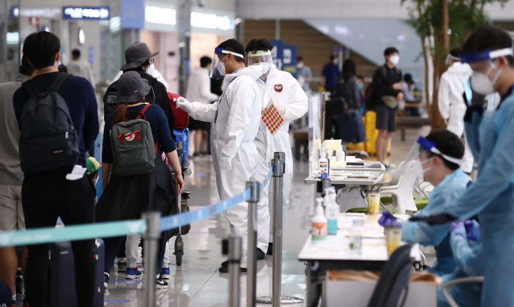 20일 오후 인천국제공항 제2여객터미널에서 네덜란드 암스테르담 등에서 온 입국자들이 방역 관계자의 안내를 받으며 입국장을 빠져나가고 있다. 연합뉴스