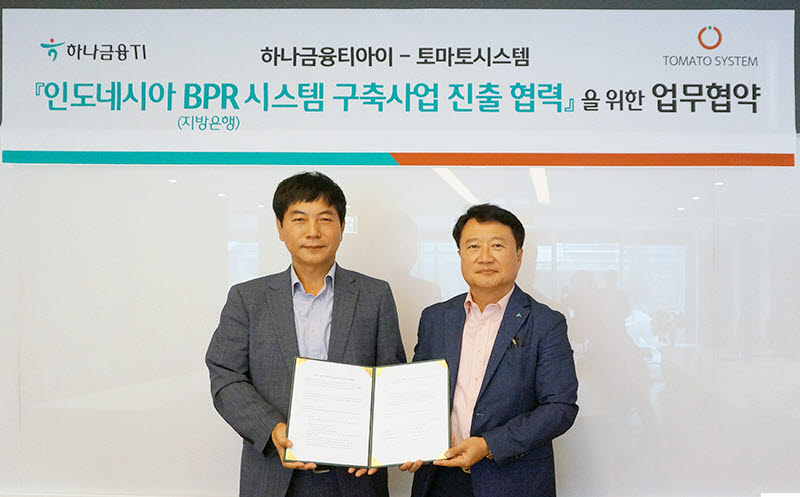 이상돈 토마토시스템 대표(왼쪽)가 유시완 하나금융티아이 대표와 업무협약서(MOU)를 교환하고 기념촬영했다.