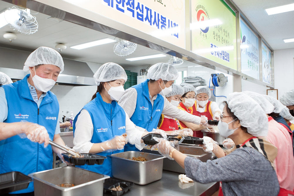 우리금융그룹 임직원 자원봉사단이 충북 충주시 충주봉사관에서 대한적십자사와 함께 전달할 음식을 직접 만들고 도시락을 포장하는 봉사활동을 하고 있다.