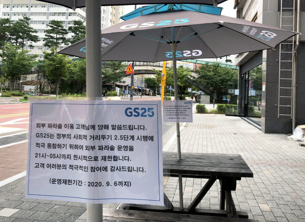 GS25 외부 파라솔에 21시~05시 미운영안내문이 부착되어 있다