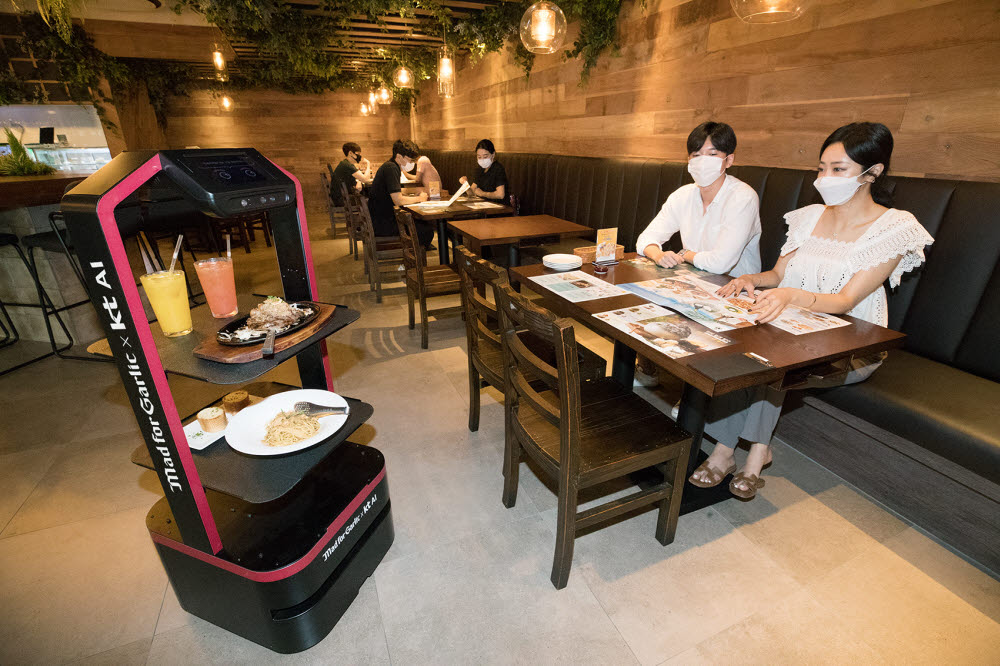 KT AI로봇이 매드포갈릭 봉은사 현대아이파크타워점에서 고객이 주문한 음식을 서빙하고 있다.