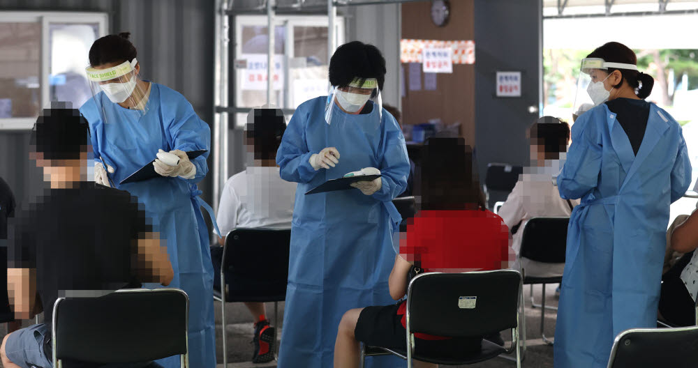 31일 오전 서울 성동구보건소에 마련된 선별진료소에서 의료진이 문진하고 있다. 연합뉴스