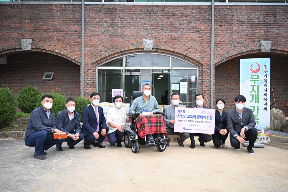 한라그룹 자동차부품 전문기업 ㈜만도와 한국교통안전공단이 전국 교통사고 피해 중증장애인 42명에게 사랑의 오뚝이 휠체어를 기증했다. 사진은 전재철 한국교통안전공단 처장(오른쪽 네번째), 김구현 만도 상무(왼쪽 세번째), 오남석 수혜자(가운데).