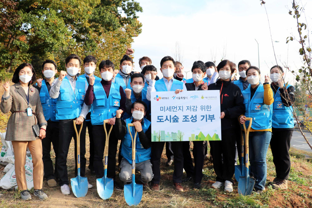 CJ대한통운임직원들과 행사 관계자들이 함께 나무를 심고 기념사진촬영을 하고있다.