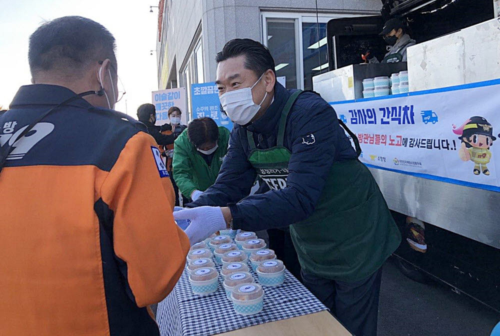 김인규 하이트진로 사장이 3일 경주소방서에 진행된 감사의 간식차 행사에 참석해 소방대원들에게 간식을 나눠 주고 있다