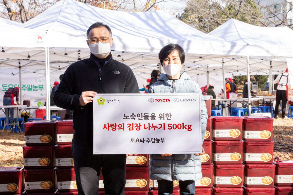 한국토요타자동차가 토요타 주말농부 가족들과 함께 손수 담근 김치 500㎏을 안나의 집에 전달했다. 타케무라 노부유키 한국토요타자동차 사장(왼쪽)과 오현숙 안나의 집 사무국장이 기념촬영을 했다.