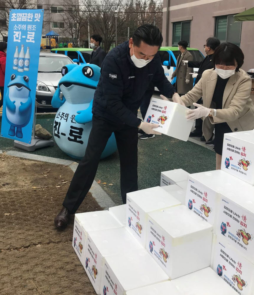 김인규 하이트진로 대표(왼쪽)가 26일 부산에서 2020 따뜻한 겨울나기 김장김치 나눔 행사에 참석해 김치를 나르고 있다.