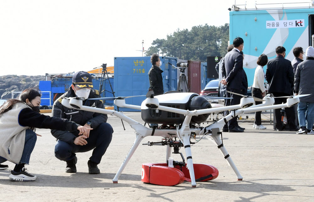 드론으로 인명구조 KT와 두산모빌리티이노베이션, 아주대학교가 응급환자 골든타임 확보를 위한 수소드론 활용 인명 구조 훈련을 30일 제주도 서귀포항에서 진행했다. 해경 관계자가 인명구조드론을 살펴보고 있다. 이동근기자 foto@etnews.com