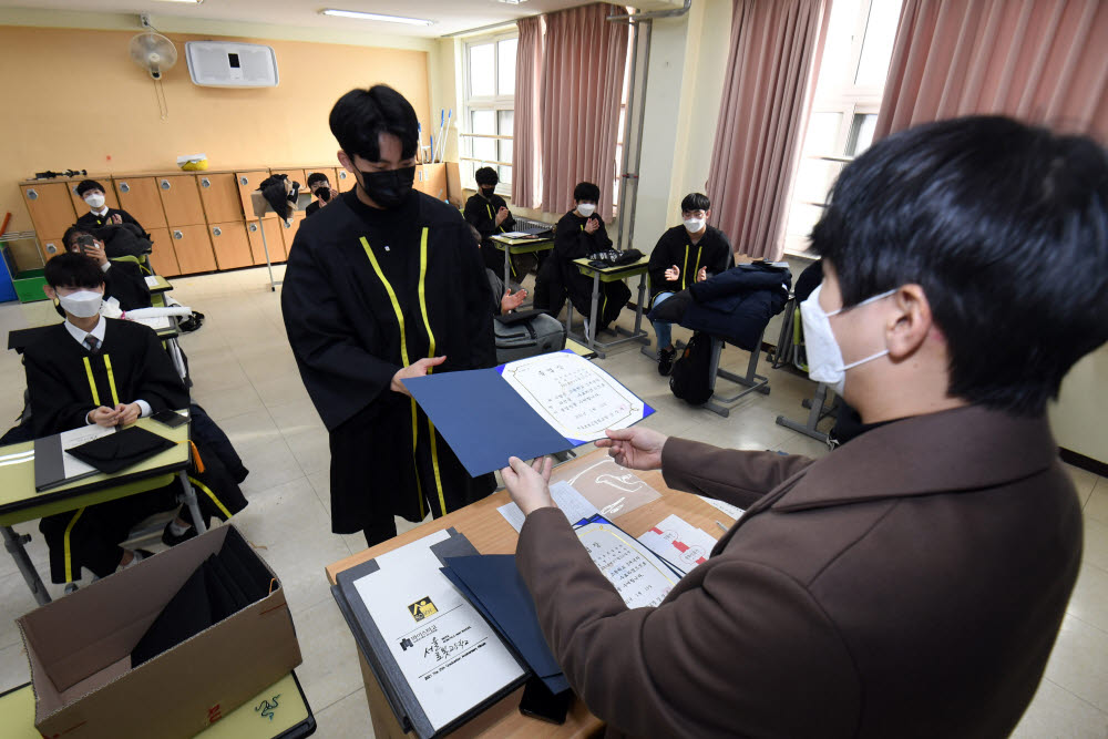 졸업식 시즌인 13일 서울 강남구 로봇고등학교에서 졸업하는 학생들이 졸업장을 받고 있다.