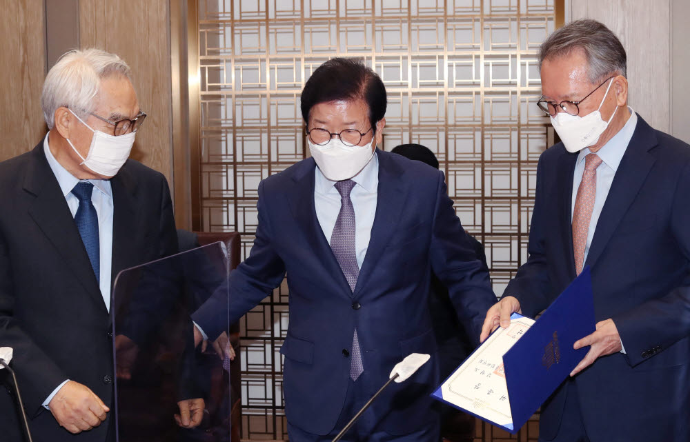 박병석 국회의장(가운데)이 3일 국회에서 열린 국회국민통합위원회 위촉식에서 김형오 전 국회의장(오른쪽)과 임채정 전 국회의장(왼쪽)에게 위원장 위촉장을 수여하고 자리를 권하고 있다. 연합뉴스.