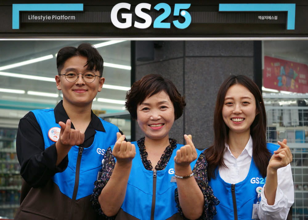 GS25 직원들과 경영주가 함께 미소지으며 하트를 그려보이고 있다. [사진=GS리테일]