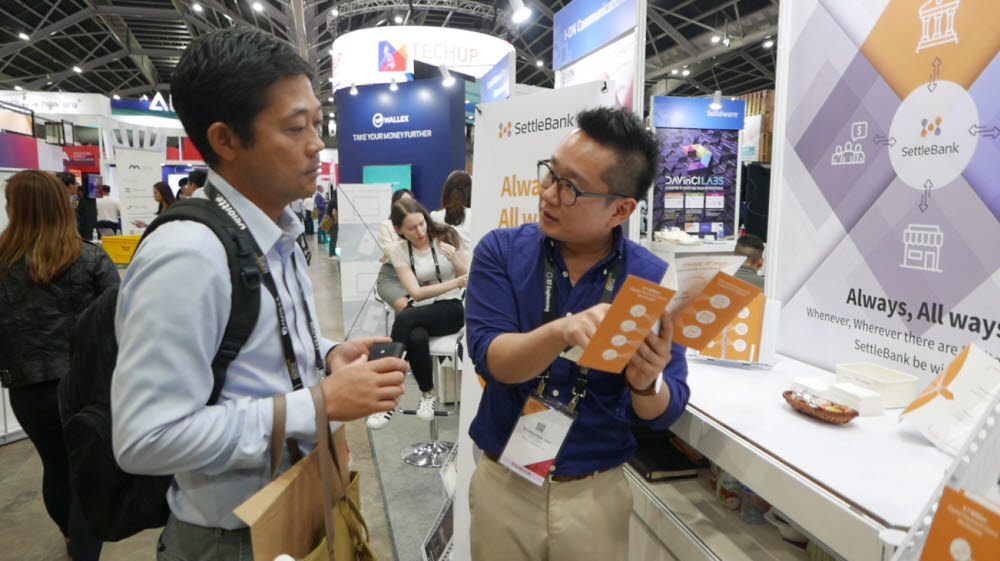 세틀뱅크 직원이 2019년 열린 싱가포르 핀테크 페스티벌에서 관람객에게 자사 결제 서비스를 설명하고 있다.