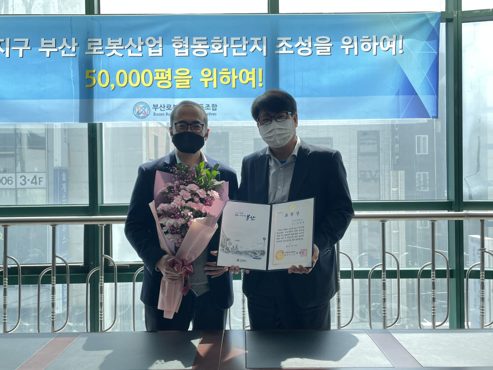 김종욱 동아대 교수(왼쪽)가 부산시장 표창장을 전달한 류현제 부산로봇산업협회 사무국장과 기념 촬영했다.