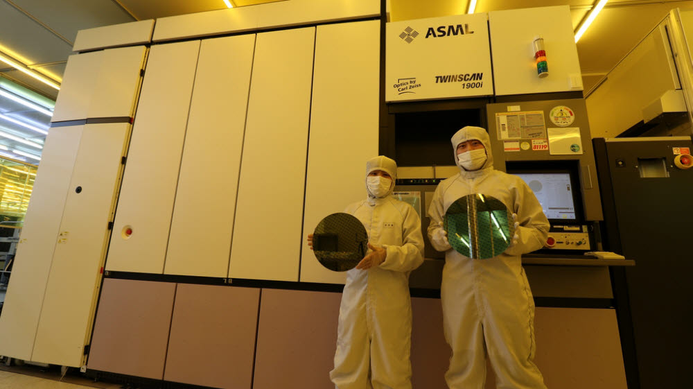 나노종합기술원 연구원들이 ASML ArF 이머전 노광장비 앞에서 40nm 패턴 웨이퍼를 들어보이고 있다. <사진=나노종합기술원>