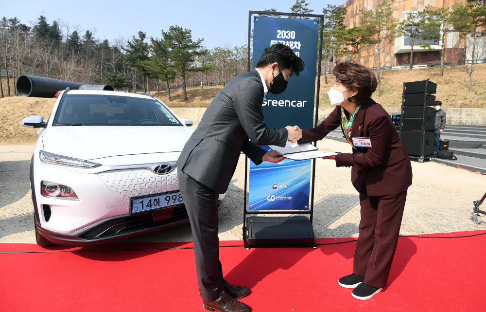 한정애 환경부 장관(오른쪽)이 김상원 그린카 대표에게 2030무공해차 전환 지정서를 전달하고 있다.