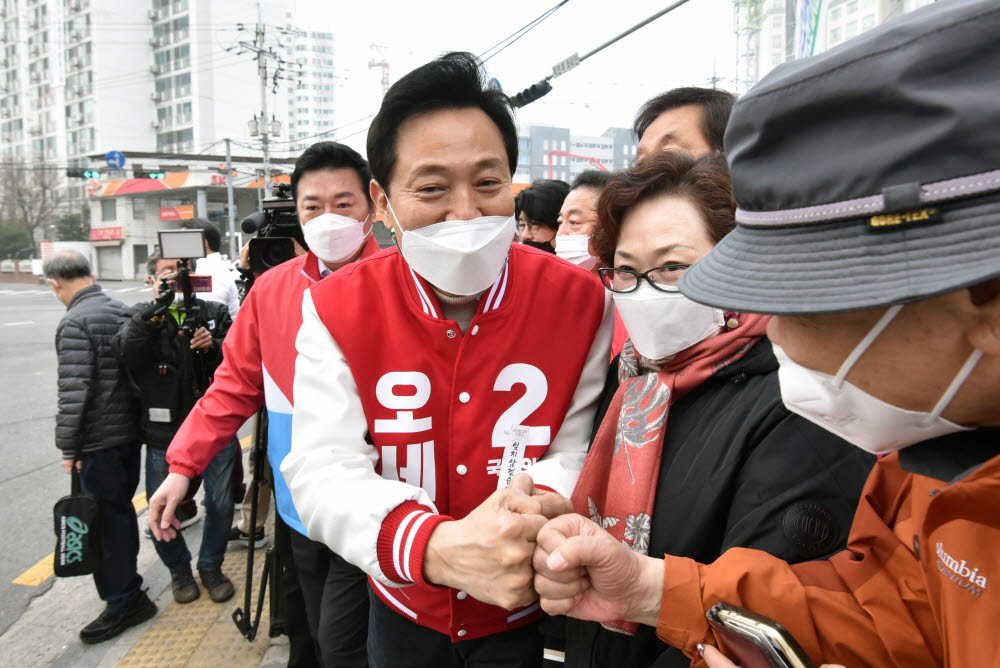 오세훈 국민의힘 서울시장 후보가 26일 서울 강서구 증미역에서 시민들과 주먹을 부딪치며 지지를 호소하고 있다.