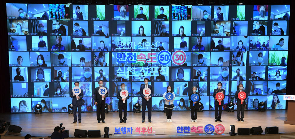 온·오프라인 참석자들이 5030 구호를 외치며 기념촬영을 하고 있다. 왼쪽부터 권용복 한국교통안전공단 이사장, 김희겸 행정안전부 재난안전관리본부장, 변창흠 국토교통부 장관, 이동국 전 국가대표 축구선수(청년대표), 송윤서 양(어린이 대표), 최명숙 씨(고령자 대표), 김창룡 경찰청장, 정지원 손해보험협회장.