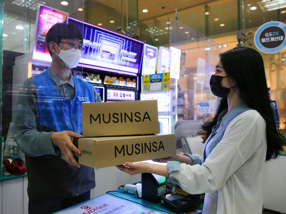 모델들이 GS25에서 무신사 박스를 전달하는 장면을 연출하고 있다.