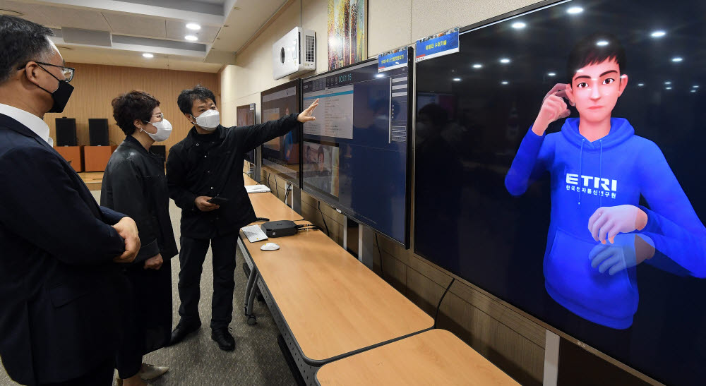 관계자가 한국전자통신연구원에서 개발한 아바타 수어 생성 시스템을 살펴보고 있다.