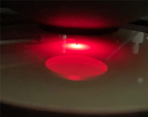 질화갈륨이 성장된 사파이어 기판에서 붉은 빛이 나오고 있는 모습.<사진=소프트에피>