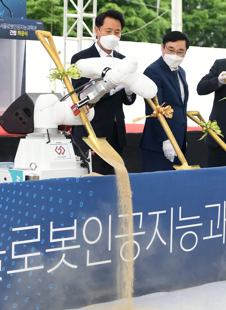 오세훈 서울시장과 이동진 도봉구청장이 두산로보틱스 협동로봇의 시삽을 지켜보고 있다.