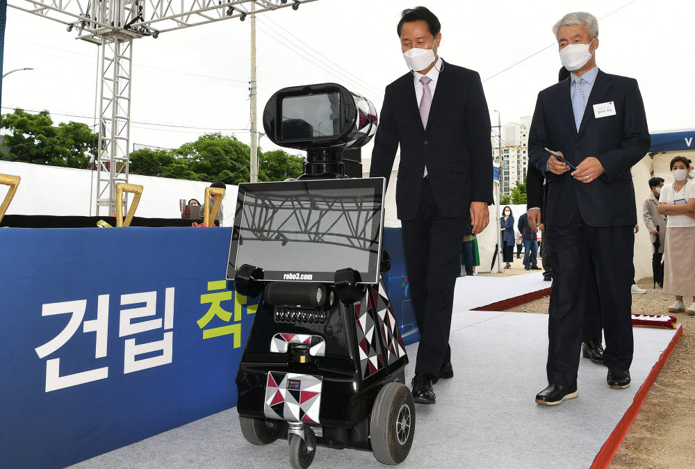 오세훈 서울 시장이 로보쓰리의 안내로봇 러비의 안내를 받으며 입장하고 있다.