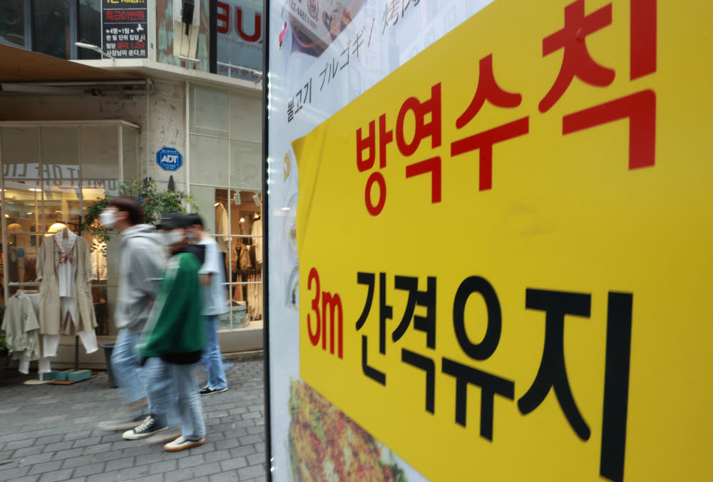 21일 서울 중구 명동 거리의 한 식당 앞에 방역수칙 안내 문구가 부착돼 있다. 연합뉴스