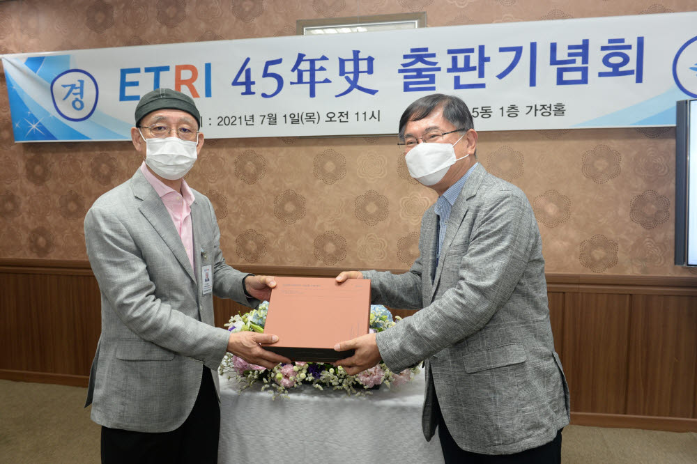 ETRI 45년사 출판기념회에서 김명준 ETRI 원장이 황승구 ETRI 45년사 편찬위원장에게 연사를 건네는 모습