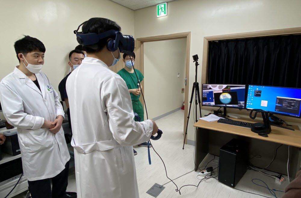 유니브이알이 개발한 양방향 척추 내시경 수술 VR 교육 시스템을 의료진이 시연하고 있다. 사진출처=유니브이알