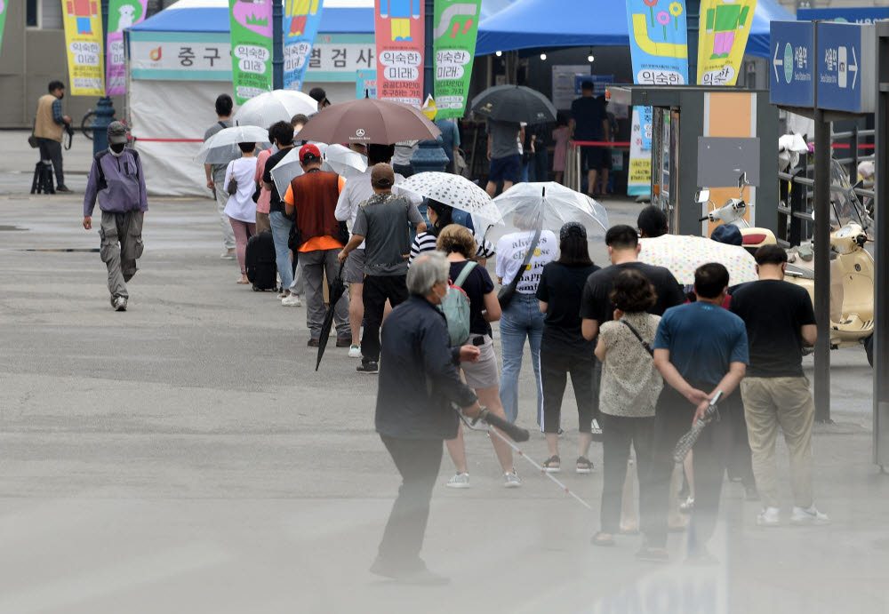 국내 코로나19 신규 확진자 수가 사흘 연속 1300명대를 기록한 주말 서울 중구 서울역광장에 마련된 임시선별검사소를 찾은 시민들이 검사를 받기 위해 줄을 서있다. 이동근기자 foto@etnews.com