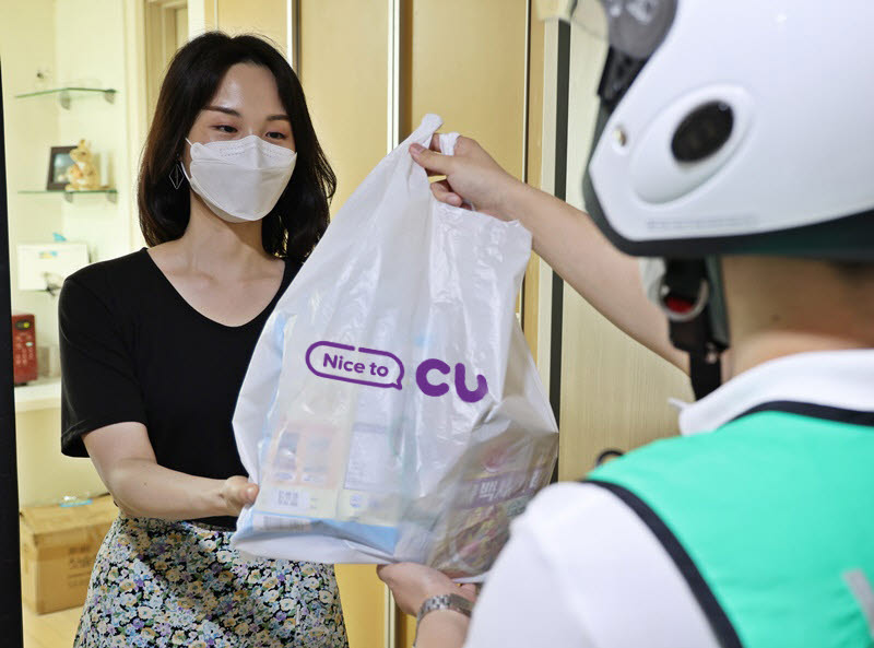 서울 삼성동에 위치한 오피스텔에서 한 고객이 CU 배달 서비스를 통해 주문한 상품을 수령하고 있다.