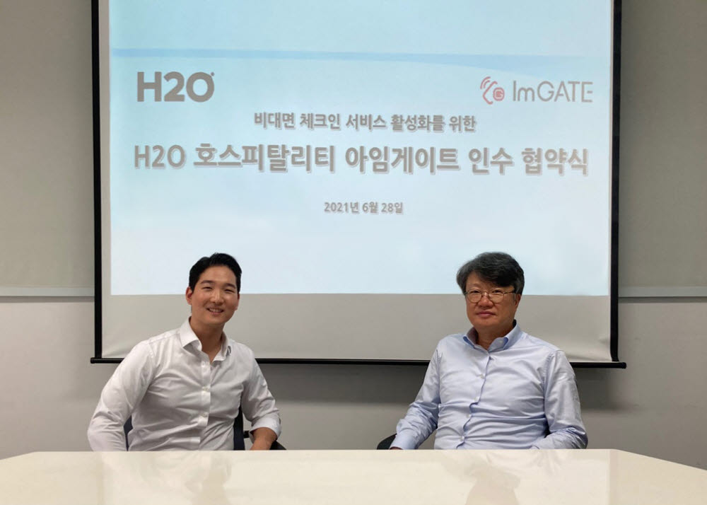 이웅희 H20호스피탈리티 대표(왼쪽)가 신창훈 아임게이트 대표와 인수협약식을 체결하고 기념촬영했다.