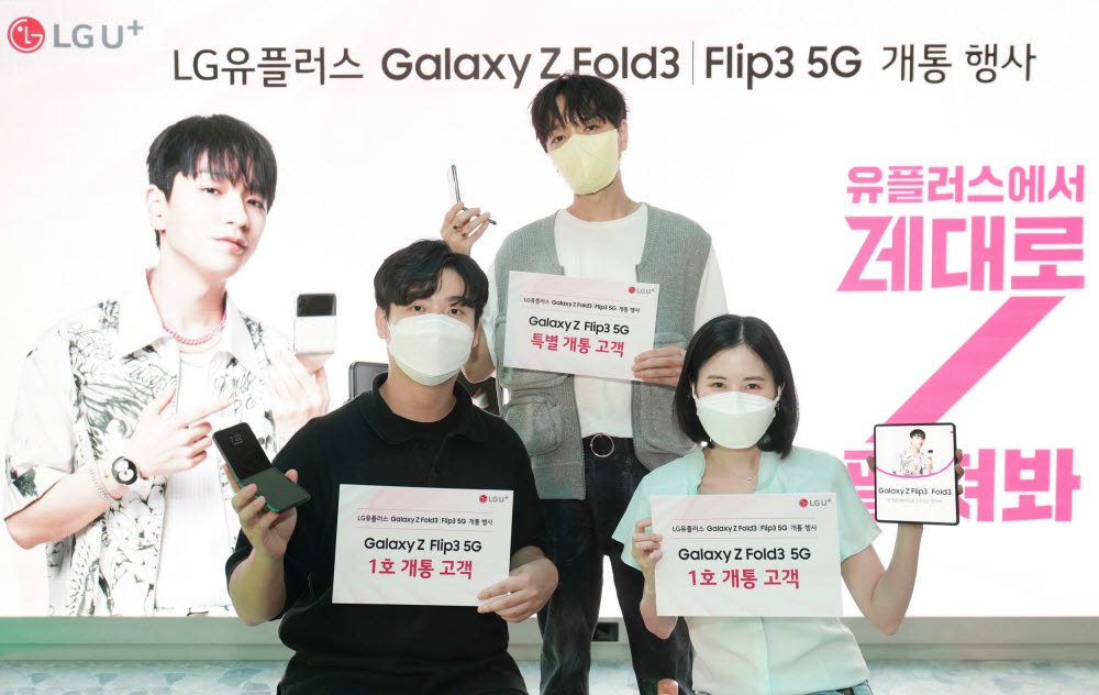 LG유플러스는 23일 오후 6시 강남역에 위치한 복합문화공간 일상비일상의 틈에서 1호 개통 고객 개통행사를 진행했다. LG유플러스 갤럭시Z 폴드3 1호 고객 민혜림 씨(첫 줄 오른쪽)와 갤럭시Z 플립3 1호 고객 류시현 씨(첫 줄 왼쪽), 그리고 LG유플러스 갤럭시Z 시리즈 광고 모델인 래퍼 사이먼 도미닉이 특별 고객으로 함께 개통을 진행했다.
