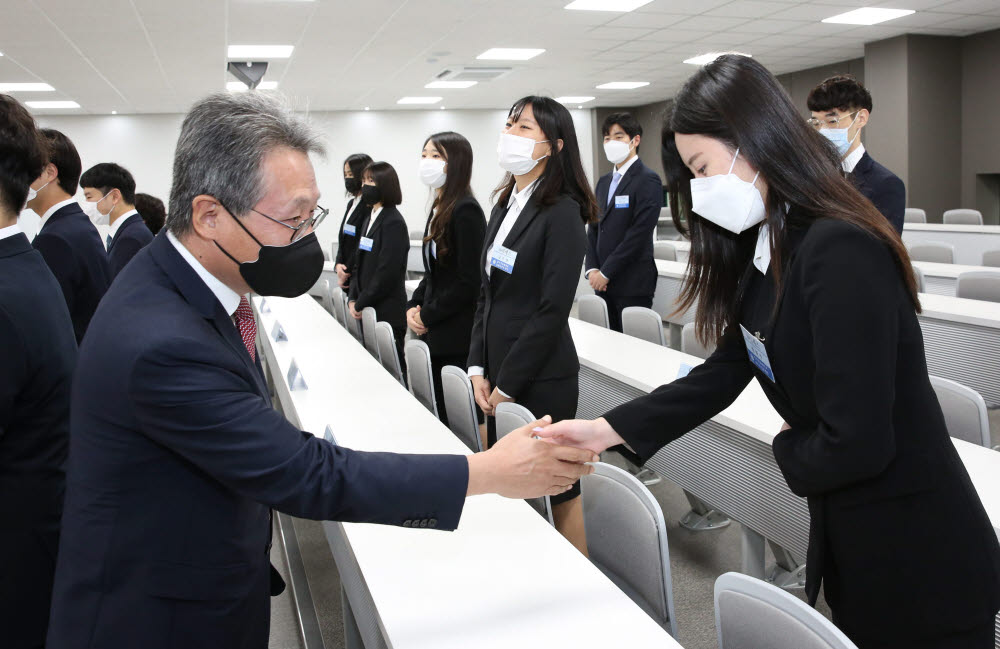 최재영 영진전문대학교 총장이 일본 취업 내정자와 악수를 하고 있다.