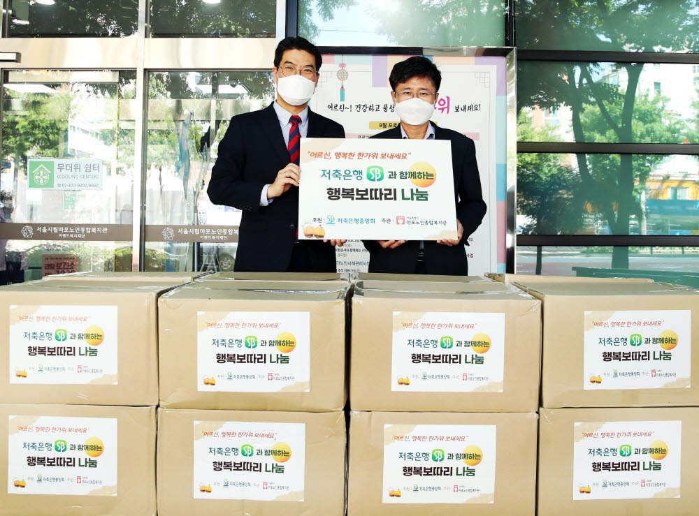 김생빈 저축은행중앙회 본부장(오른쪽)과 김윤태 서울시립마포노인종합복지관 관장이 8일 식료품 키트 전달식을 마치고 기념촬영했다.