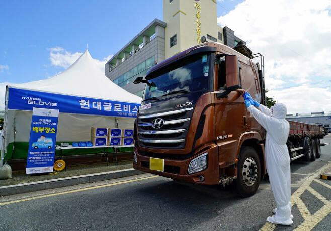 현대글로비스 관계자가 지난 27일 울산화물터미널을 이용하는 화물차 운전자에게 안전용품세트를 전달하고 있다.