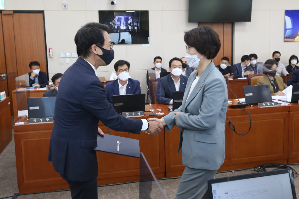 임혜숙 장관(오른쪽)이 이원욱 과방위원장에게 선서문을 전달한 후 악수하고 있다.