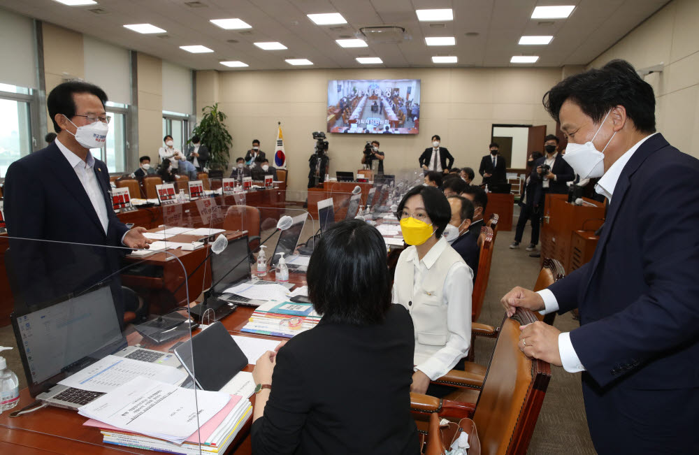 더불어민주당 김영진 간사(오른쪽)와 국민의힘 류성걸 간사가 정의당 장혜영 의원과 기본소득당 용혜인 의원에게 국감 개의가 늦어지는 이유를 설명하고 있다. 국민의힘 류성걸 간사는 "대장동 개발사업 관련 여야가 노트북에 부착한 인쇄물을 제거하지 않으면 회의를 개의할 수 없다고 윤후덕 위원장이 입장을 밝혔다"고 말했다.