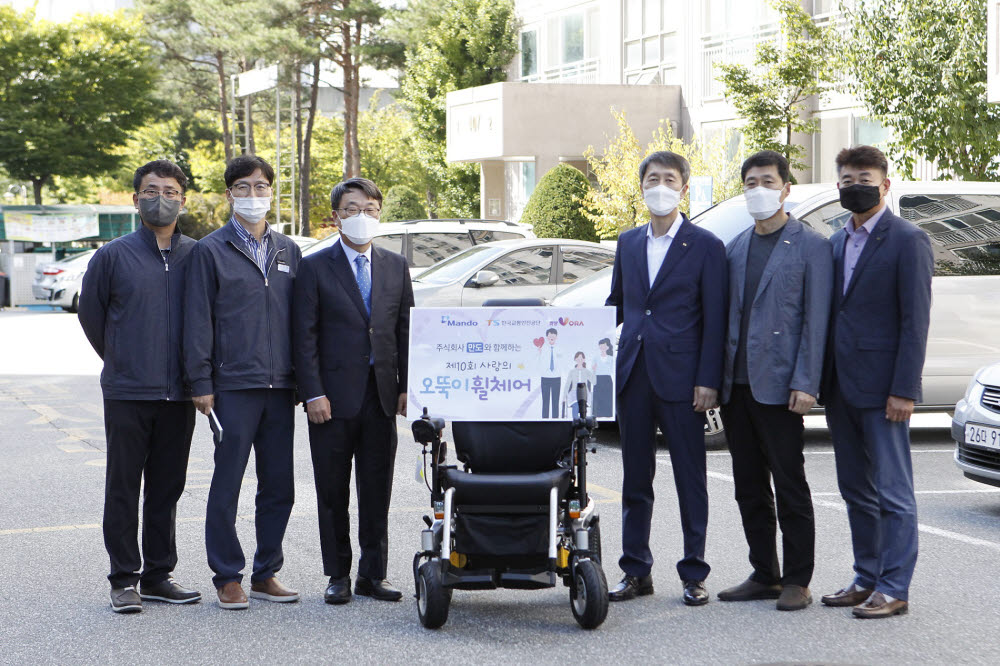 만도는 한국교통안전공단과 지난달 30일 강원도 원주시에 거주하는 수혜자 자택을 방문해 사랑의 오뚝이 휠체어 기증식을 가졌다. 사진은 이장규 한국교통안전공단 강원본부장(오른쪽에서 세번째), 홍영일 만도 상무(〃 네번째)